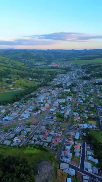 Vista aérea de Nova Fátima, Paraná, com ruas, casas e colinas ao fundo
